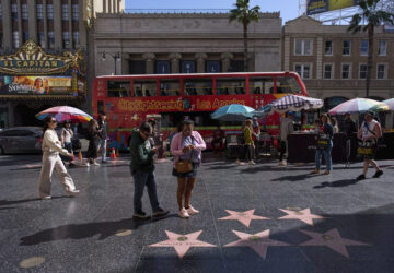 Tourists walk along the Hollywood Walk of Fame in Los Angeles, Friday, April 4, 2025. (AP Photo/Jae C. Hong)