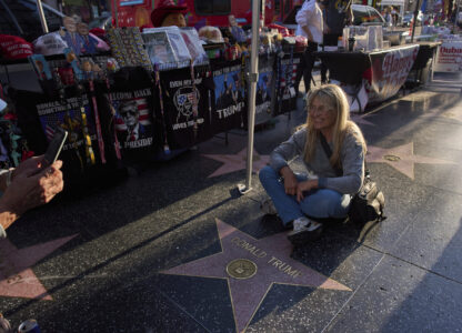 Silvia Camino, visiting from Argentina, takes photos with the Donald Trump star on the Hollywood Walk of Fame in Los Angeles, Friday, April 4, 2025. (AP Photo/Jae C. Hong)