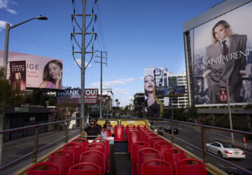 Tourists ride a double-decker bus along the Sunset Strip in Los Angeles, Friday, April 4, 2025. (AP Photo/Jae C. Hong)