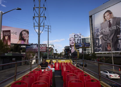 Tourists ride a double-decker bus along the Sunset Strip in Los Angeles, Friday, April 4, 2025. (AP Photo/Jae C. Hong)
