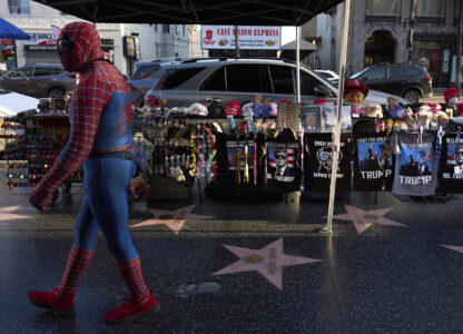 A street performer dressed as Spider Man walks along the Hollywood Walk of Fame past the Donald Trump star and Trump merchandise in Los Angeles, Friday, April 4, 2025. (AP Photo/Jae C. Hong)
