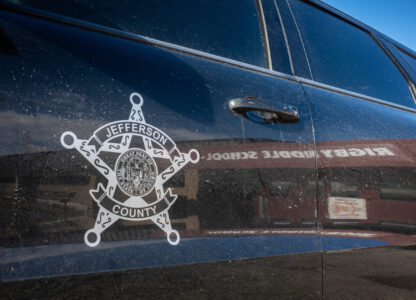 This image provided by Idaho Education News shows the entrance to Rigby Middle School is seen in the reflection of a Jefferson County Sheriff's vehicle in Rigby, Idaho on Wednesday, Feb. 5, 2025. (John Roark/Idaho Education News via AP)