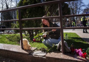 Kateryna Sitak, 23, a teacher, cries while laying flowers and toys on a site of a Russian missile strike in Sumy, Ukraine, Monday, April 14, 2025. (AP Photo/Evgeniy Maloletka)