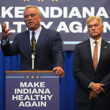 U.S. Health and Human Services Secretary Robert F. Kennedy, Jr speaks as Centers for Medicare and Medicaid Services Administrator Dr. Mehmet Oz listens during a Make Indiana Healthy Again initiative event in Indianapolis, Tuesday, April 15, 2025. (AP Photo/Michael Conroy)