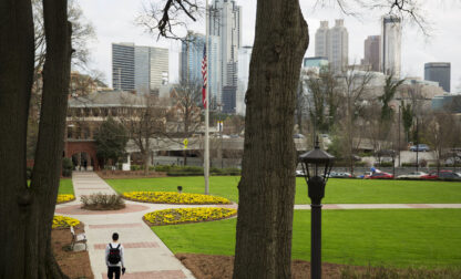 FILE - A person walks through the Georgia Tech campus with the downtown skyline in the background, March 11, 2016, in Atlanta. (AP Photo/David Goldman, File)