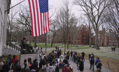 Visitors stop at the statue of John Harvard in Harvard Yard at Harvard University, Tuesday, April 15, 2025, in Cambridge, Mass. (AP Photo/Charles Krupa)