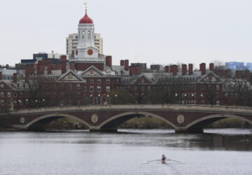 A sculler rows down the Charles River near Harvard University, at rear, Tuesday, April 15, 2025, in Cambridge, Mass. (AP Photo/Charles Krupa)
