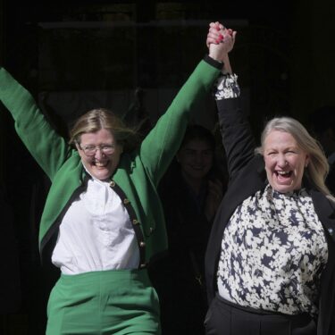 Marion Calder, right, and Susan Smith, left, from For Women Scotland, celebrate outside after the U.K. Supreme Court ruled that a woman is someone born biologically female, excluding transgender people from the legal definition in a long-running dispute between the feminist group and the Scottish government, in London Wednesday, April 16, 2025. (AP Photo/Kin Cheung)