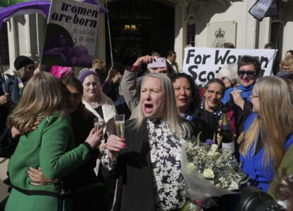 Marion Calder, center, and Susan Smith, left, from For Women Scotland, celebrate outside after the U.K. Supreme Court ruled that a woman is someone born biologically female, excluding transgender people from the legal definition in a long-running dispute between the feminist group and the Scottish government, in London Wednesday, April 16, 2025. (AP Photo/Kin Cheung)