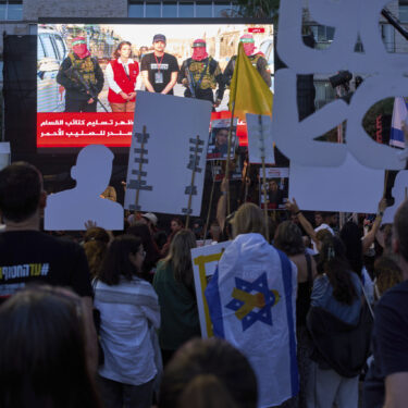 People watch a live broadcast of Israeli-American soldier Edan Alexander as he is released from Hamas captivity in Gaza, at a plaza known as the hostages square in Tel Aviv, Monday, May 12, 2025. Alexander was abducted during the Hamas-led attack on his base on October 7, 2023. (AP Photo/Oded Balilty)