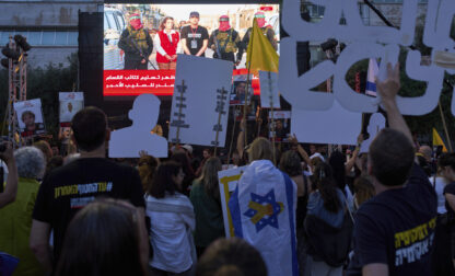People watch a live broadcast of Israeli-American soldier Edan Alexander as he is released from Hamas captivity in Gaza, at a plaza known as the hostages square in Tel Aviv, Monday, May 12, 2025. Alexander was abducted during the Hamas-led attack on his base on October 7, 2023. (AP Photo/Oded Balilty)