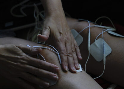 Priscilla Grim applies electrotherapy pads to her knees on April 18, 2025, at her apartment in New York. (AP Photo/Julia Demaree Nikhinson)