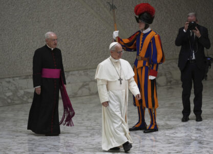 Pope Leo XIV, followed by the caretaker of the Papal Household, Bishop Leonardo Sapienza, arrives to meet with members of the international media in the Paul VI Hall at the Vatican, Monday, May 12, 2025. (AP Photo/Domenico Stinellis)