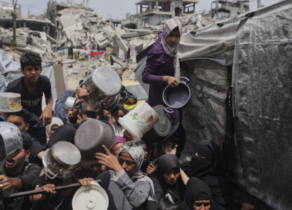 Palestinians struggle to get donated food at a community kitchen in Jabalia, northern Gaza Strip, Thursday, May 15, 2025. (AP Photo/Jehad Alshrafi)