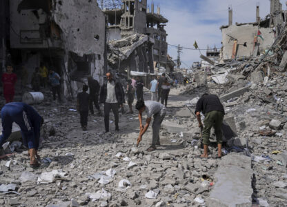 Palestinians clean the rubble along a road beside a clinic destroyed by Israeli airstrikes in Jabalia, in the northern Gaza Strip, on Thursday, May 15, 2025. (AP Photo/Jehad Alshrafi)