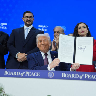 President Donald Trump, center, holds up a signed Board of Peace charter during the Annual Meeting of the World Economic Forum in Davos, Switzerland, Thursday, Jan. 22, 2026. (AP Photo/Evan Vucci)