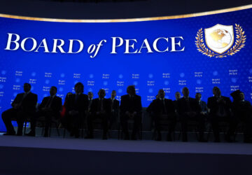 President Donald Trump, center, sits on stage with international leaders after the signing of a Board of Peace charter during the Annual Meeting of the World Economic Forum in Davos, Switzerland, Thursday, Jan. 22, 2026. (AP Photo/Evan Vucci)