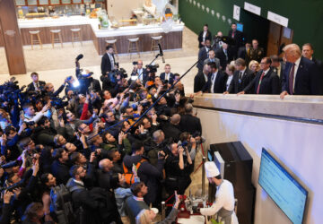 Journalist ask questions to President Donald Trump, right, as he walks up a stairwell during the Annual Meeting of the World Economic Forum in Davos, Switzerland, Thursday, Jan. 22, 2026. (AP Photo/Evan Vucci)