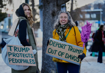 Two women with posters attend a demonstration against United States President Donald Trump and the Annual Meeting of the World Economy Forum in Davos, Switzerland, Sunday, Jan. 18, 2026. (AP Photo/Markus Schreiber)