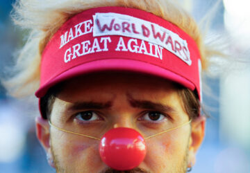 A man dressed as a clown waits for the start of a demonstration against President Trump and the Annual Meeting of the World Economy Forum in Davos, Switzerland, Sunday, Jan. 18, 2026. (AP Photo/Markus Schreiber)