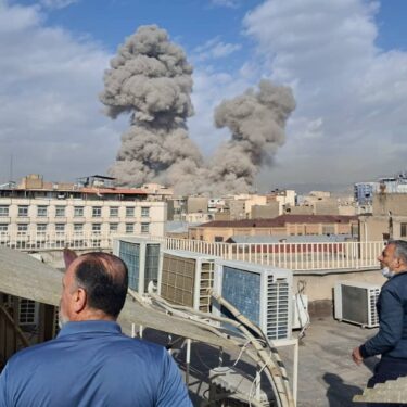 FILE - People watch as smoke rises on the skyline after an explosion in Tehran, Iran, Feb. 28, 2026. (AP Photo, File)