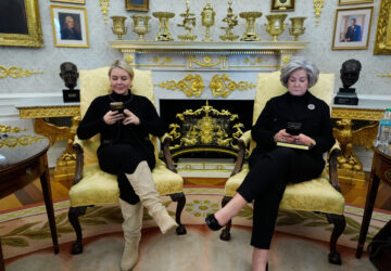 FILE - White House press secretary Karoline Leavitt and White House chief of staff Susie Wiles check their phones as President Donald Trump speaks in the Oval Office of the White House in Washington, Feb. 2, 2026. (AP Photo/Alex Brandon, File)