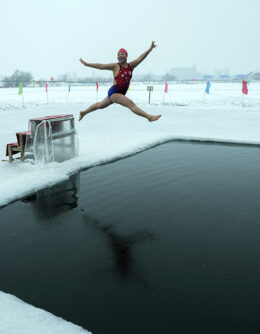 Yu Xiaofeng leaps into a pool carved from ice on the frozen Songhua river in Harbin in northeastern China's Heilongjiang province, Jan. 7, 2025. (AP Photo / Andy Wong)