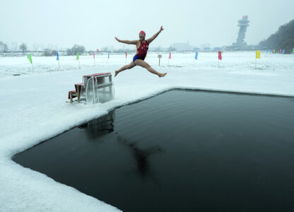 Yu Xiaofeng leaps into a pool carved from ice on the frozen Songhua river in Harbin in northeastern China's Heilongjiang province, Jan. 7, 2025. (AP Photo / Andy Wong)