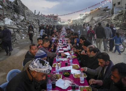 Palestinians sit at a large table surrounded by the rubble of destroyed homes and buildings as they gather for iftar, the fast-breaking meal, on the first day of Ramadan in Rafah, southern Gaza Strip, March 1, 2025. (AP Photo / Abdel Kareem Hana)
