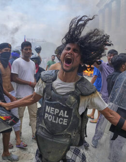 A protester wearing flak jacket and carrying a shield snatched from a policeman shouts slogans at the Singha Durbar, the seat of Nepal's government's various ministries and offices during a protest against social media ban and corruption in Kathmandu, Nepal, Sept. 9, 2025. (AP Photo / Niranjan Shrestha)